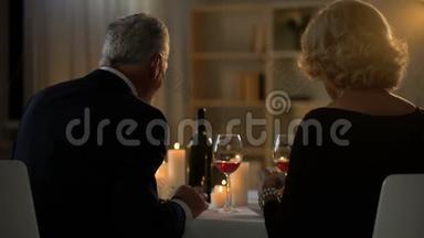 年长的幸福夫妇吃晚餐喝葡萄酒，周年庆典